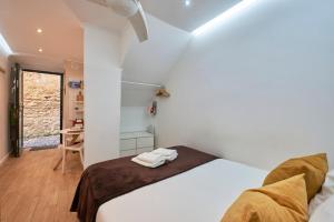 biała sypialnia z łóżkiem i stołem w obiekcie Mini Studio in Alfama near Castelo St Jorge w Lizbonie