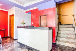 a lobby with red and white walls and stairs at Ouro Hotel in Vespasiano