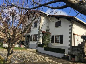 a white house with a tree in front of it at EKIALDE rural in Arantza