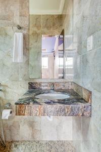 uma casa de banho com um lavatório e um espelho em Ouro Hotel em Vespasiano