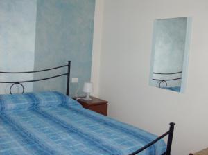 um quarto com uma cama com um cobertor xadrez azul em Casa Amalia em Boario Terme