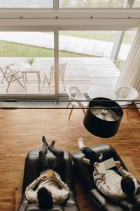 twee mensen op een bank in een woonkamer bij Nebesa Chalets in Kobarid +35 foto's