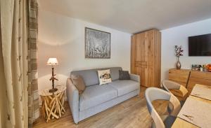 ein Wohnzimmer mit einem Sofa und einem Tisch in der Unterkunft Saalbacher Perle Top 4 in Saalbach-Hinterglemm