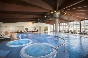 ein großer Pool mit zwei Whirlpools in der Unterkunft Corinthia Baška Sunny Hotel in Baška