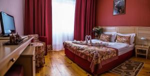 Schlafzimmer mit einem Bett mit roten Wänden und einem TV in der Unterkunft Seasons SPA Boutique Hotel in Kozin
