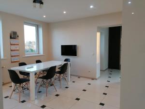 a room with a table and chairs and a tv at Kempings "Ceļmalnieki" in Liepāja
