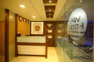 a lobby of a store with a surfboard on the wall at Hotel White Mount in Chennai