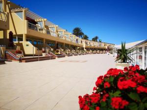 a courtyard of a resort with red flowers at Atlantic Beach Club in Playa del Ingles