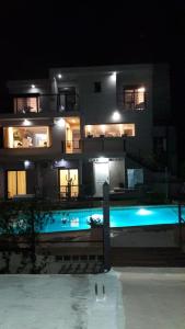 un gran edificio con piscina por la noche en Vivaldi Suites en Villa Carlos Paz