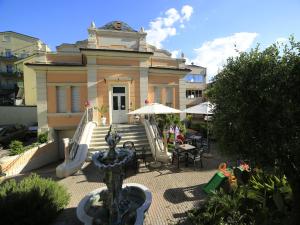 a building with a fountain in front of it at EURO b&b in Cattolica