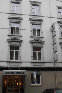 a white building with a sign on the side of it at Hotel Topas Frankfurt City in Frankfurt/Main