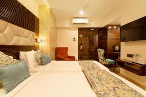 a hotel room with a bed and a desk at Hotel Auris in Mumbai