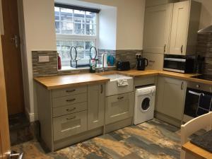 a kitchen with a sink and a washing machine at Country Retreat in Highpeak Junction