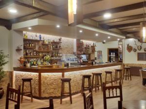 un bar en un restaurante con taburetes de madera en Hotel Arume, en Bóveda