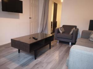 a living room with a coffee table and a couch at Glasgow Hampden Garden Flat in Glasgow