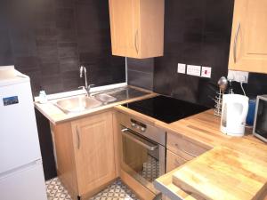 a kitchen with a sink and a stove top oven at Glasgow Hampden Garden Flat in Glasgow