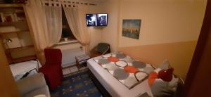 - une petite chambre avec un lit et un fauteuil rouge dans l'établissement Hans-Eidig, à Stelle
