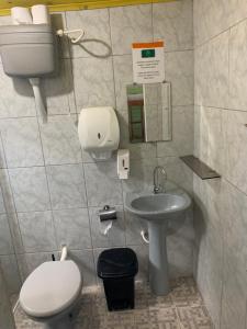 a small bathroom with a toilet and a sink at Hostel Encantadas Ecologic in Ilha do Mel +31 photos