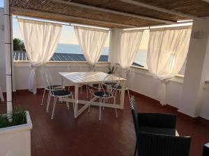 balcón con mesa, sillas y vistas al océano en La terrazza sul mare, en Santa Marinella