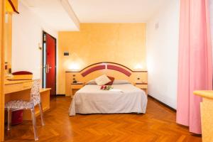 Cette chambre comprend un lit, une table et un bureau. dans l'établissement Hotel Regent - In pieno Centro, à San Benedetto del Tronto