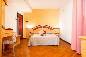 una camera d'albergo con letto, tavolo e scrivania di Hotel Regent a San Benedetto del Tronto