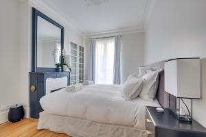 a white bedroom with a large bed and a mirror at Elegant Family Apt 5 pers - Bon Marché in Paris