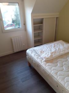 ein Schlafzimmer mit einem weißen Bett und einem Fenster in der Unterkunft Maison proche de l ocean in Saint-Gildas-de-Rhuys