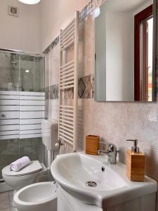 a white bathroom with a sink and a toilet at Talìa B & B in Agira