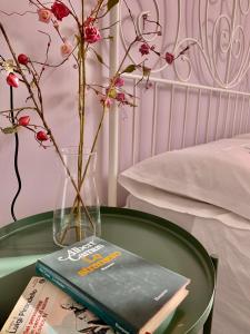 un tavolo verde con un libro e un vaso con fiori di Talìa B & B ad Agira