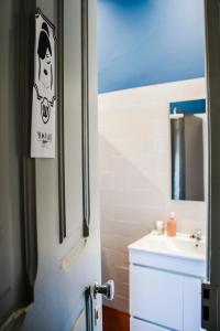 uma casa de banho com um lavatório e uma porta com uma placa em Most Art Boutique Hostel em Leiria