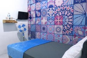 ein Schlafzimmer mit einer Wand mit einer bunten Kachelwand in der Unterkunft Griya Joyo 2 Syariah in Malang