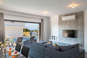 a living room with a couch and a television at Villa Marlene, walking distance to Coral Beach! in Peyia