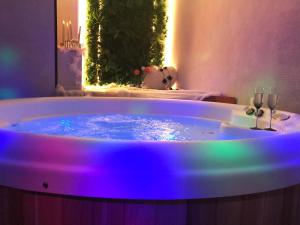 a bath tub with purple lights in a bathroom at Les Aires en Scènes au bord de l'eau in Épagne-Épagnette
