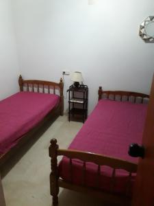 two beds in a room with pink sheets at playa mar 2 in Alfaz del Pi