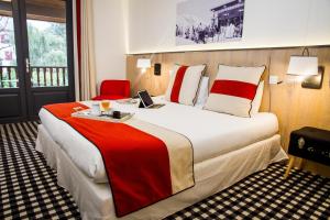 Habitación de hotel con cama grande y ordenador portátil. en Hôtel Mir, en Saint-Lary-Soulan