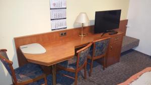 a wooden desk with a computer and a television at Haus am Sonnenhang in Wasungen