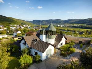 - une vue aérienne sur une maison blanche avec une tourelle dans l'établissement Weingut & Gästehaus Schumann, à Lieser