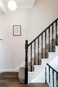 a staircase in a home with white walls and black railings at HSA - Shoreditch in London