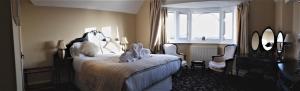 1 dormitorio con cama, ventana y espejo en Gable End Hotel, en Great Yarmouth