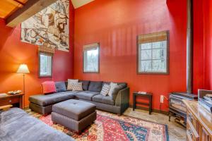 a living room with a couch and red walls at Berry Glen Redwood Park Loft in Orick