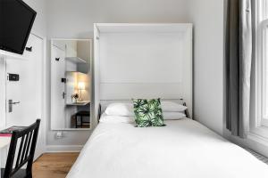 a bedroom with a white bed with a pillow on it at HSA - Shoreditch in London