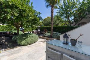 a garden with a fence and a table with a lamp at Apartments and rooms Villa Bori in Poreč