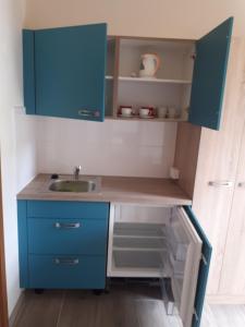 a kitchen with blue cabinets and a sink at Penzion Loren in Františkovy Lázně