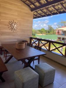 a dining room with a table and chairs and a large window at Village Itacimirim in Itacimirim