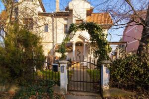 a gate in front of a white house with ivy at Penthouse ''Lookout'' in Belgrade