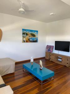 a living room with a couch and a tv at Village Itacimirim in Itacimirim