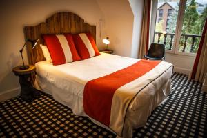 Un dormitorio con una cama grande y una ventana. en Hôtel Mir, en Saint-Lary-Soulan