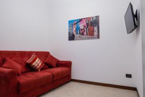 un divano rosso in un soggiorno con una foto sul muro di Sweet Venice - Exclusive near San Marco - WiFi a Venezia
