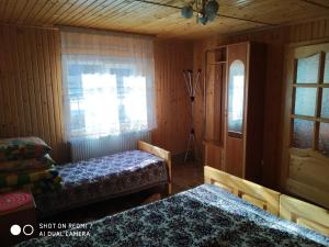 1 dormitorio con 2 camas y ventana en У ДЯДЬКА, en Pilipets