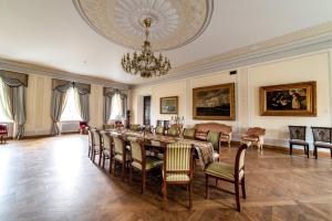 une salle à manger avec une table, des chaises et un lustre dans l'établissement Burbiskio dvaras, à Anykščiai